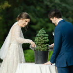 bride and groom watering pine tree